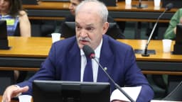 Deputado fala ao microfone em audiência pública sobre critérios de avaliação biopsicossocial em concursos públicos, na Câmara dos Deputados