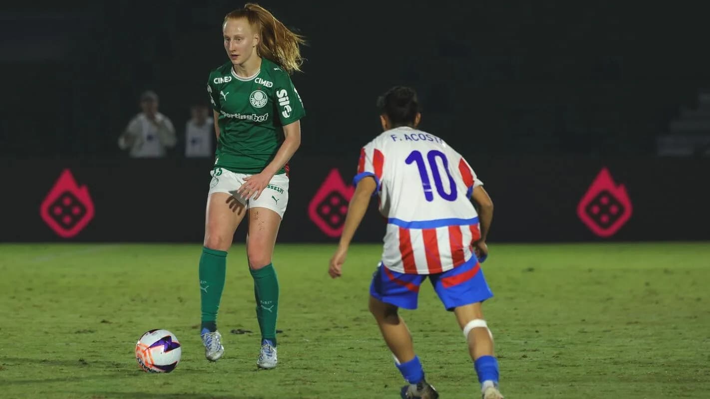 Jogadora do Palmeiras disputa a bola com adversária em partida de futebol feminino