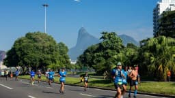 Corredores disputam prova de rua em avenida arborizada