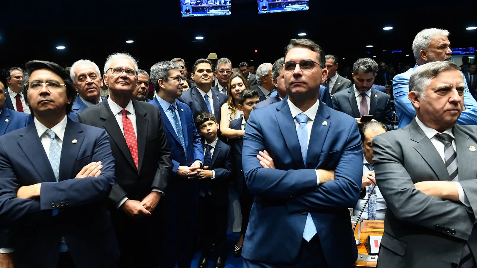 Flávio Bolsonaro, de braços cruzados e óculos escuros, no plenário do Senado