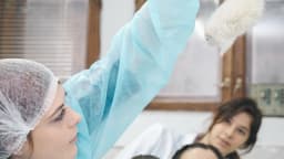 Pesquisadora de jaleco segura camundongo de laboratório em ambiente científico, foto de arquivo
