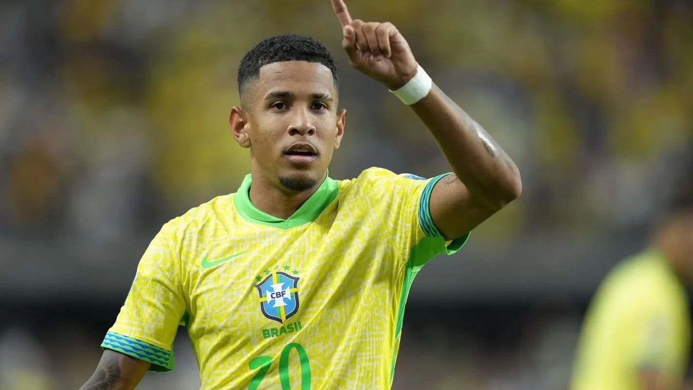 Savinho comemora com a camisa da Seleção Brasileira, apontando para o alto
