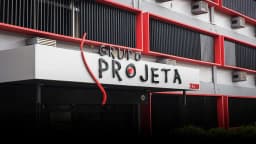 Fachada da sede do Grupo Projeta, com o letreiro da marca sobre a entrada do prédio