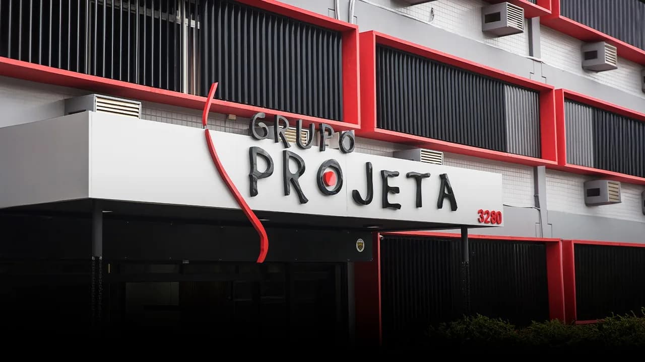 Fachada da sede do Grupo Projeta, com o letreiro da marca sobre a entrada do prédio