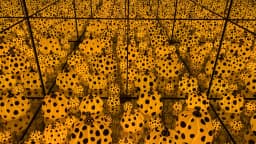 Instalação de abóboras amarelas com bolinhas pretas em sala de espelhos infinitos, obra de Yayoi Kusama