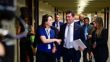 Senador Sergio Moro caminha por corredor do Senado cercado de assessores e jornalistas