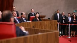 Ministra Estela Aranha, de toga preta, sentada na bancada do TSE durante cerimônia de posse