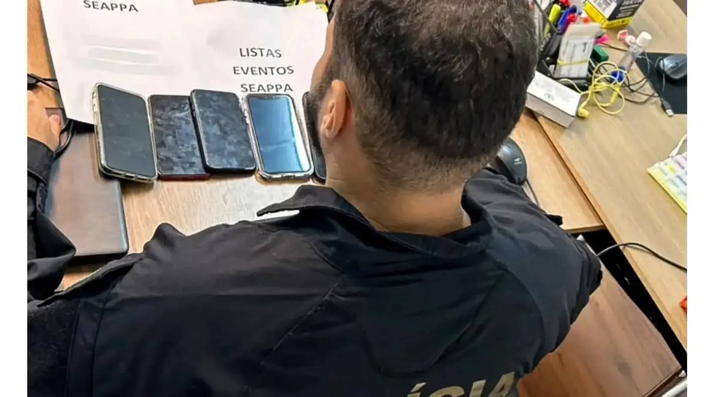 Agente da Polícia Federal examina celulares apreendidos durante operação (foto de arquivo)