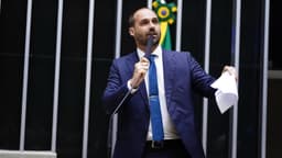 Em foto de arquivo de 2023, o então deputado Eduardo Bolsonaro discursa na tribuna da Câmara dos Deputados, com microfone na mão e papéis na outra