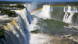 Vista panorâmica das Cataratas do Iguaçu com arco-íris sobre as quedas d'água