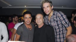 Zezé Di Camargo sorrindo ao lado de outras pessoas em evento