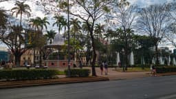 Praça da Liberdade, em Belo Horizonte, com pessoas caminhando entre o coreto e os chafarizes