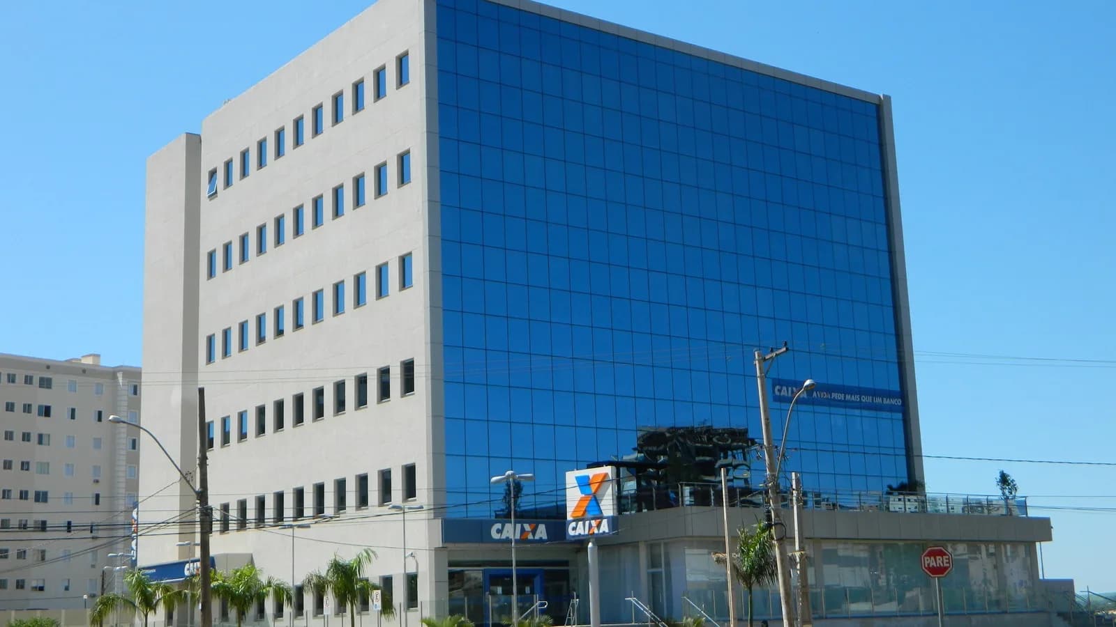 Fachada de agência da Caixa Econômica Federal, com logotipo do banco em destaque