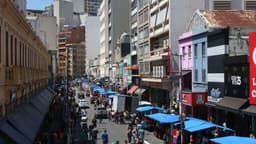 Rua de comércio popular movimentada no centro de São Paulo, com lojistas e consumidores (foto de contexto)