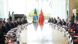 Lula e Xi Jinping em reunião bilateral, com bandeiras do Brasil e da China ao fundo
