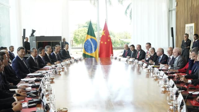 Lula e Xi Jinping em reunião bilateral, com bandeiras do Brasil e da China ao fundo