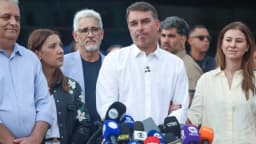Flávio Bolsonaro fala à imprensa ao lado da mulher e das filhas antes de embarcar para Miami