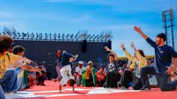 Apresentação cultural com dançarinos de rua em frente a multidão durante ato de campanha de Lula
