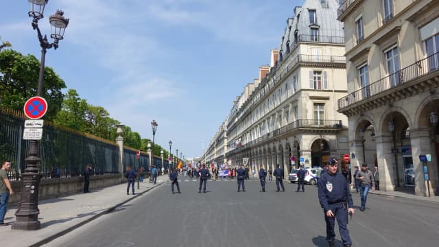 Policiais franceses da CRS enfileirados em rua de Paris durante manifestação, com prédios históricos ao fundo (foto de arquivo)