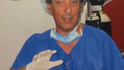 Gastroenterologista em trajes cirúrgicos segurando equipamento de endoscopia