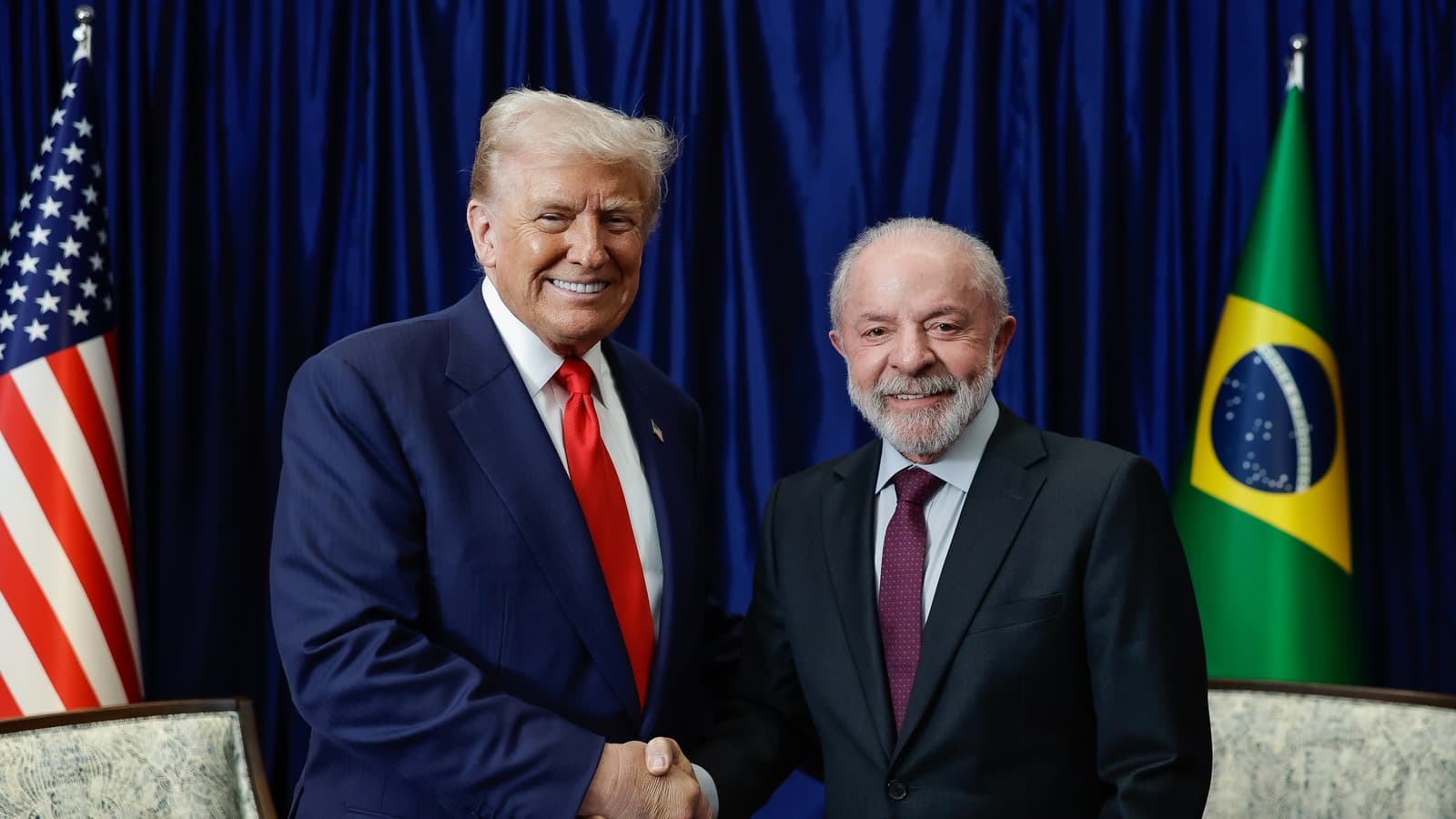 Em foto de arquivo de outubro de 2025, Lula e Donald Trump apertam as mãos diante das bandeiras do Brasil e dos Estados Unidos durante encontro na Cúpula da Asean, na Malásia