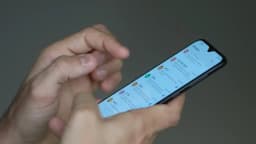 Mãos seguram um smartphone durante uso de aplicativo