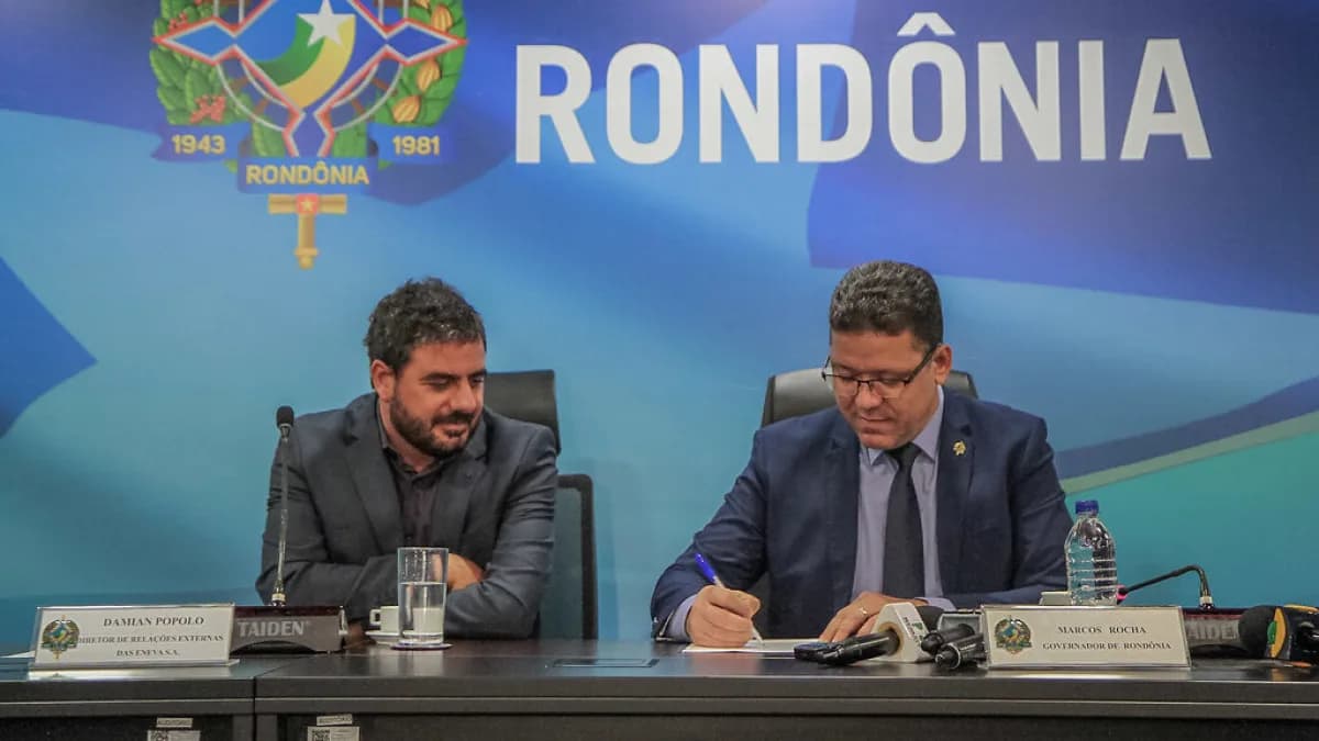 Executivos assinam memorando de entendimento em mesa de reunião