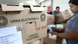 Urna eletrônica em caixa de transporte durante procedimento de carga e lacração da Justiça Eleitoral