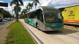 Ônibus articulado do sistema Move, de Belo Horizonte, trafegando por avenida arborizada