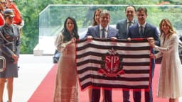 Tarcísio de Freitas em cerimônia oficial no Palácio dos Bandeirantes, segurando a bandeira de São Paulo