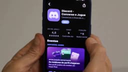 Mãos seguram um smartphone exibindo a página do aplicativo Discord numa loja de apps