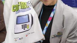 Participante de evento do TSE com influenciadores digitais segura bolsa com material sobre eleições 2026