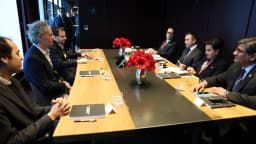 Alex Karp, de cabelo grisalho cacheado e blazer escuro, em reunião de trabalho em Davos