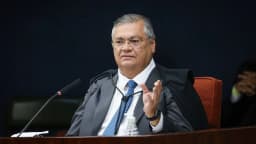 Ministro Flávio Dino, de toga, gesticula durante sessão do STF
