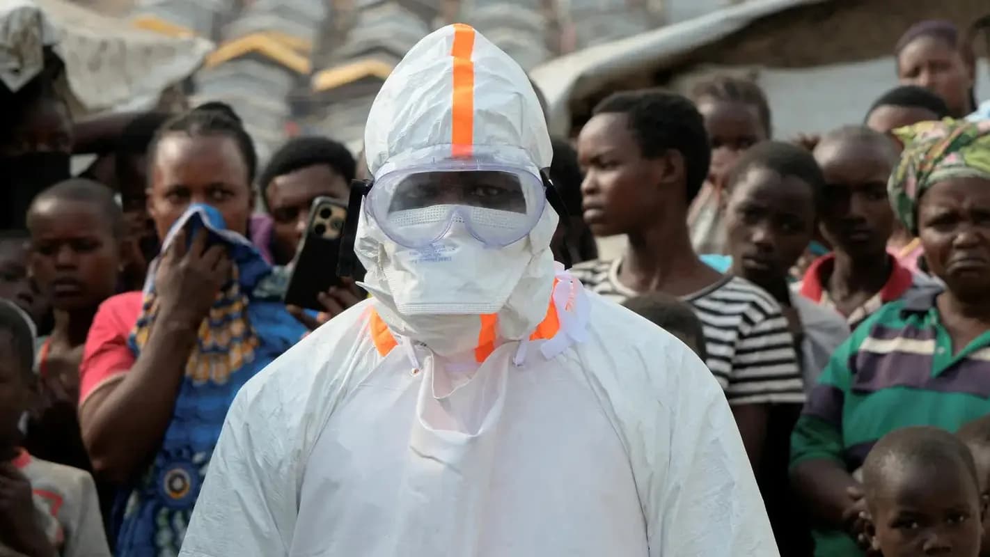 Profissional de saúde com traje de proteção completo contra Ebola, cercado por moradores na República Democrática do Congo