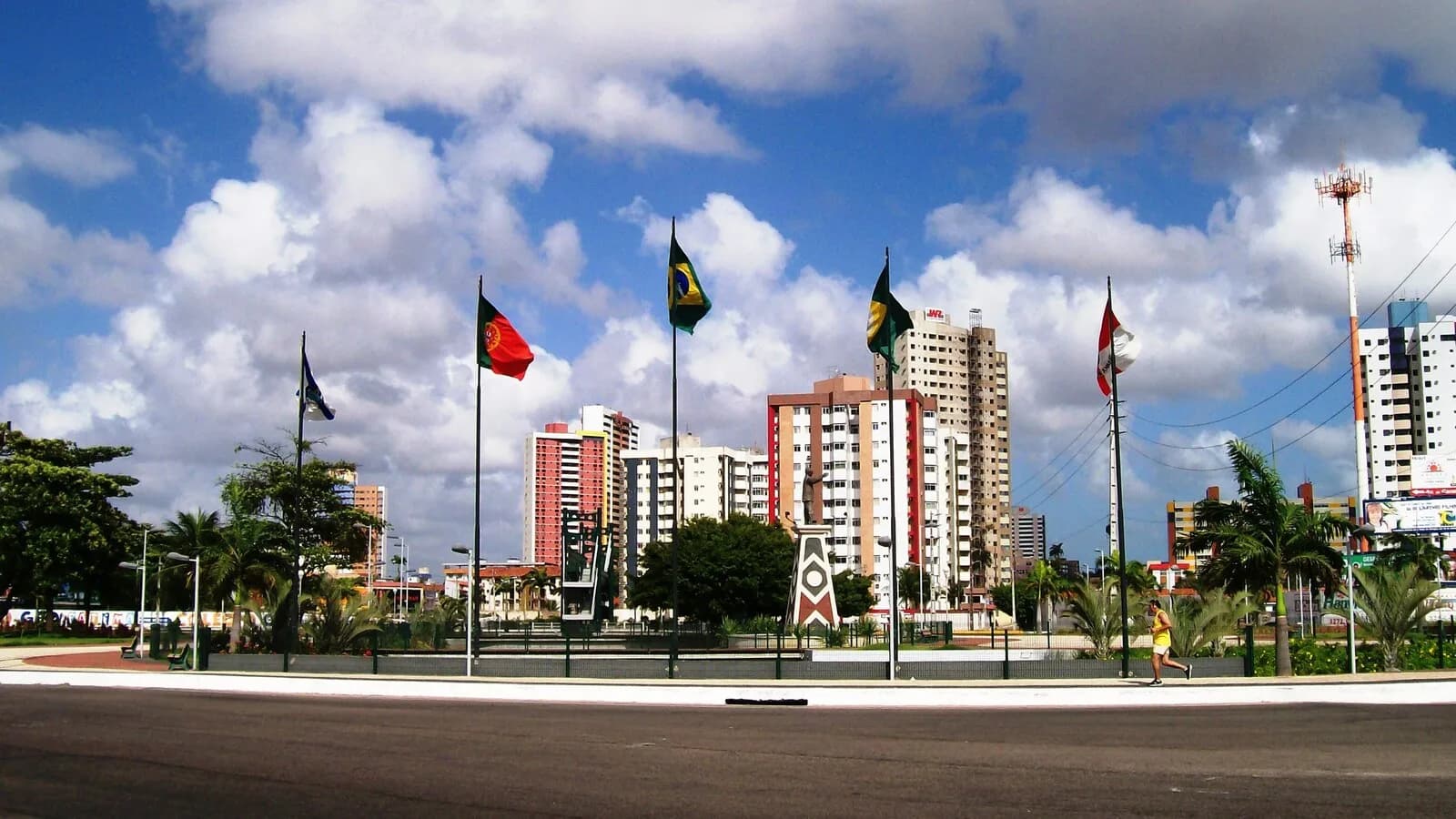 Vista da entrada da cidade de Fortaleza, no Ceará, com prédios e bandeiras ao fundo