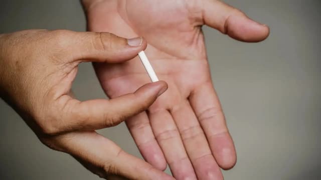 Mão segura pequeno dispositivo branco, foto de arquivo de ação da Anvisa contra produtos estéticos sem registro sanitário