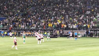 Jogadores do Palmeiras em campo durante partida da Libertadores, com estádio cheio ao fundo