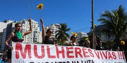 Mulheres seguram girassóis e faixa "Mulheres Vivas" durante ato em Copacabana, no Rio de Janeiro, pela votação do PL da Misoginia