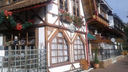 Fachada de restaurante em estilo europeu com estrutura de madeira aparente na Vila Capivari, Campos do Jordão