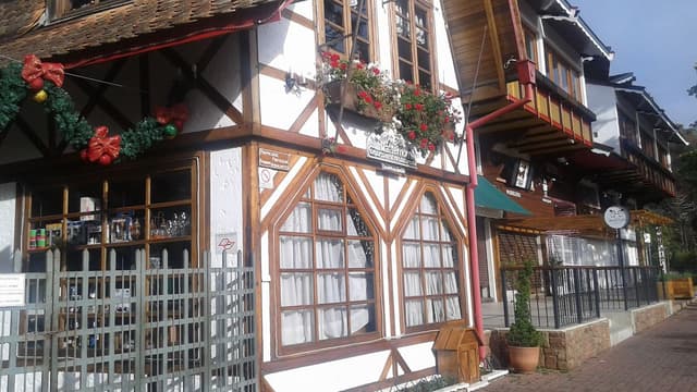 Fachada de restaurante em estilo europeu com estrutura de madeira aparente na Vila Capivari, Campos do Jordão