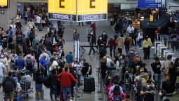 Multidão de passageiros com malas em terminal de aeroporto