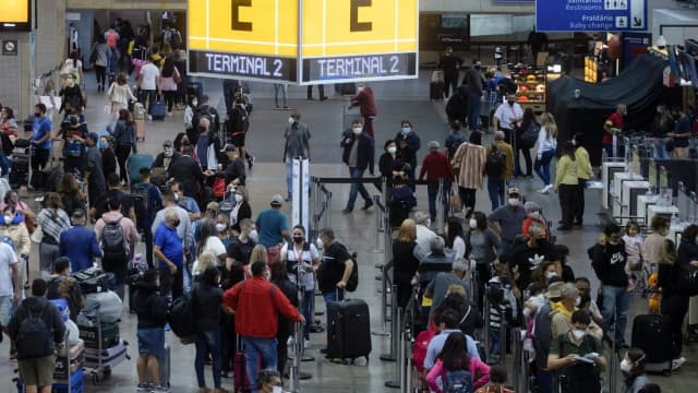Multidão de passageiros com malas em terminal de aeroporto