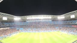Vista panorâmica da Arena do Grêmio lotada durante uma partida noturna