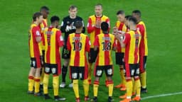Jogadores do RC Lens reunidos em campo, com o uniforme listrado vermelho e amarelo do clube (imagem de arquivo)