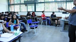 Professor dá aula para turma de estudantes em sala de aula