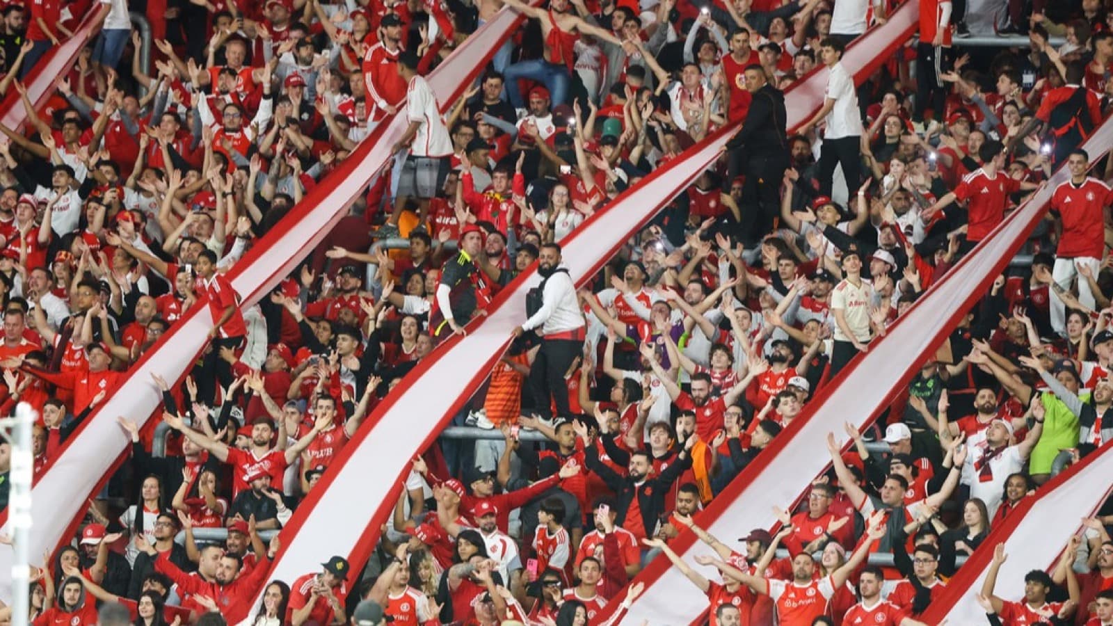 Torcida do Internacional com bandeirões vermelhos e brancos no Beira-Rio durante o jogo contra o Corinthians