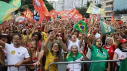 Multidão com bandeiras do Brasil e bandeiras de partidos em ato de apoio no Rio de Janeiro