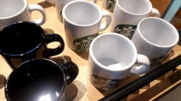 Canecas da Starbucks expostas em balcão de cafeteria da marca em Curitiba, no Paraná