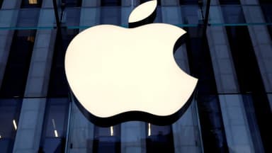 Logo da Apple iluminado na fachada de uma loja da marca